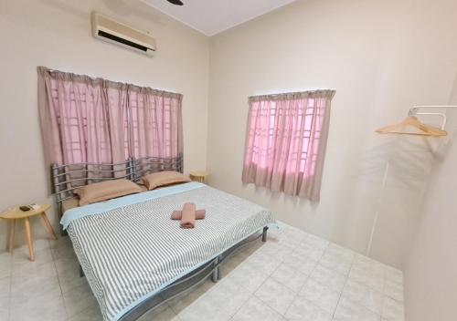 太平Air-home No 9 Kampung Boyan, 4BR, 9pax, Netflix的一间卧室配有一张带粉红色窗帘和粉红色玩具的床。