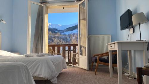 圣雅克·德波尔布吕内酒店的一间卧室配有一张床、一台电视和一个阳台