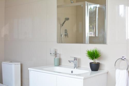察嫩The Pickle Residence的白色的浴室设有水槽和镜子