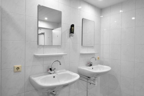 Dinteloord哈文兹科特旅馆的白色的浴室设有两个盥洗盆和镜子