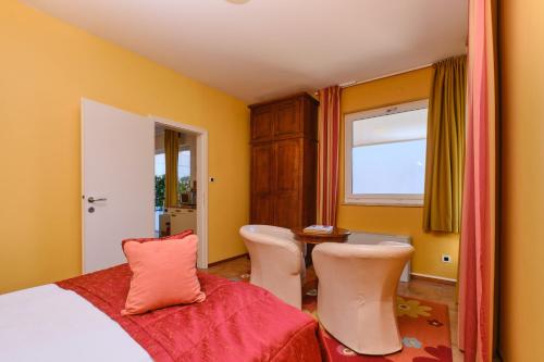 木洛希尼梅尔梅尔套房酒店的卧室配有一张床和一张桌子及椅子