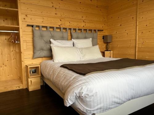 马尔比伊松Hôtel L'Atelier de Donat的一间卧室配有一张带木墙的大床