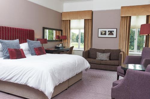 迪德科特米尔顿山之家酒店的一间卧室配有一张床、一张沙发和一把椅子