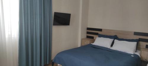 巴库里阿尼Nias's Apartment in Bakuriani的卧室配有一张床铺,墙上配有电视