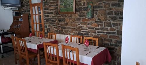 瓦尔德卡多斯Casa Samarra的一间设有桌椅和砖墙的用餐室