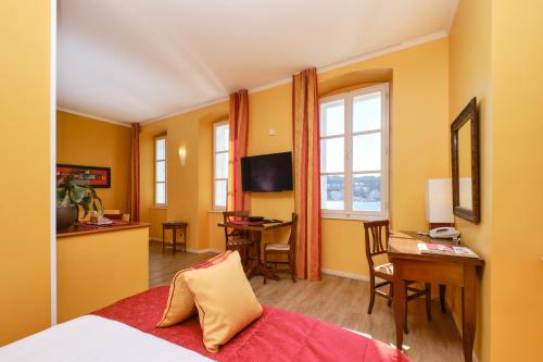 木洛希尼梅尔梅尔套房酒店的配有一张床、一张桌子和一张桌子的酒店客房