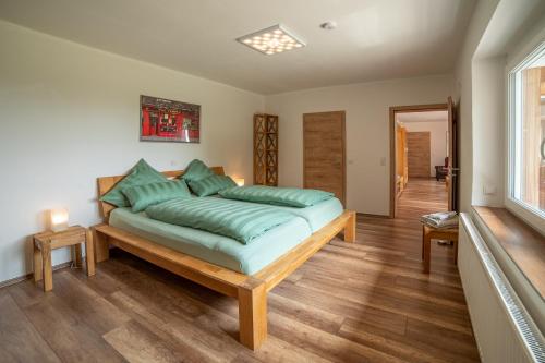 SchöfwegFerienbungalow Sonnenwald Bayerischer Wald的一间卧室配有一张带绿色枕头的大床