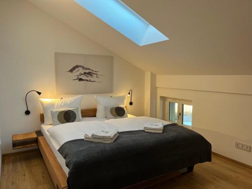 格门德蒂格斯Gmunder Premium Dachgeschoss-Apartments的一间卧室配有一张大床和两条毛巾