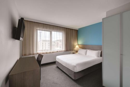 霍巴特霍巴特旅客之家酒店的一间卧室配有一张床、一张书桌和一台电视
