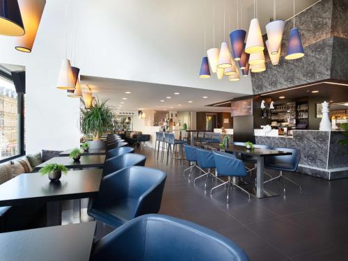 卢森堡拉蒂森卢森堡市公园旅馆的一间设有蓝色椅子和桌子的餐厅