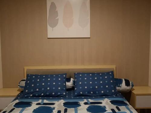PulosirihMaxxy room grand Kamala lagoon的一间卧室配有一张带蓝色和白色枕头的床