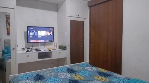 PulosirihMaxxy room grand Kamala lagoon的一间卧室配有一张床、一台电视和一张书桌