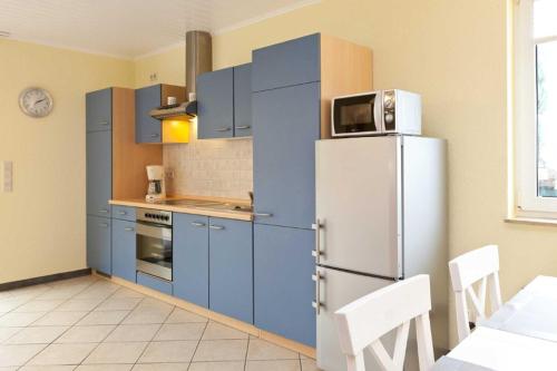 克林克FH Wendorff的厨房配有蓝色橱柜和冰箱。