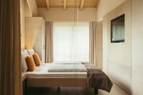 魏森湖Strandhotel am Weissensee的一间卧室设有一张床和一个窗口