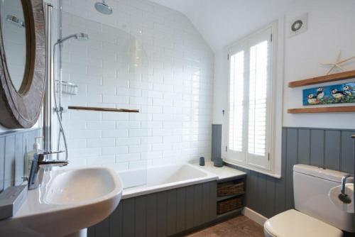 巴姆博格Periwinkle的一间带水槽、浴缸和镜子的浴室