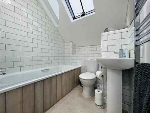 弗罗姆Stable Cottage的浴室配有卫生间、盥洗盆和浴缸。