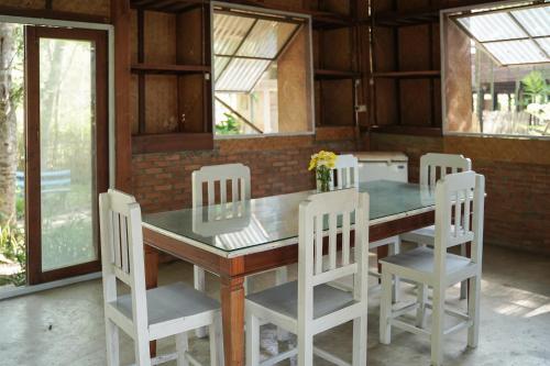 清道Art House at Chiangdao - Waterlily House的餐桌、四把白色椅子和桌子