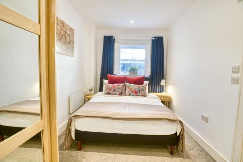 林肯Pass the Keys Centrally Located Apartment的一间卧室配有一张带红色枕头和镜子的床
