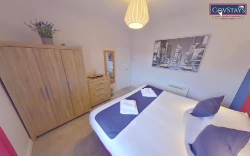 考文垂Sunnyside View - 1-bed Apartment in Coventry City Centre的一间卧室配有一张床和一个木制橱柜