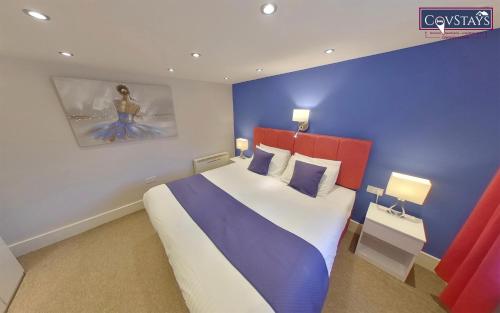 考文垂City Retreat - 1-bed Apartment in Coventry City Centre的一间卧室设有一张蓝色墙壁的大床