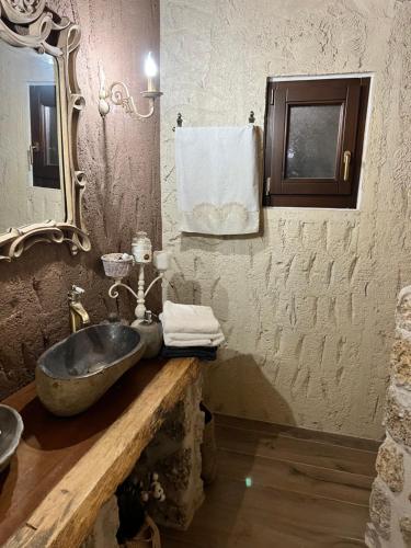 克兰尼蒂giagias family farm的一间带石制水槽和镜子的浴室