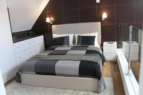 萨卡文Terreirinho 1 e 2的一间卧室配有一张大床,铺有黑白床单。