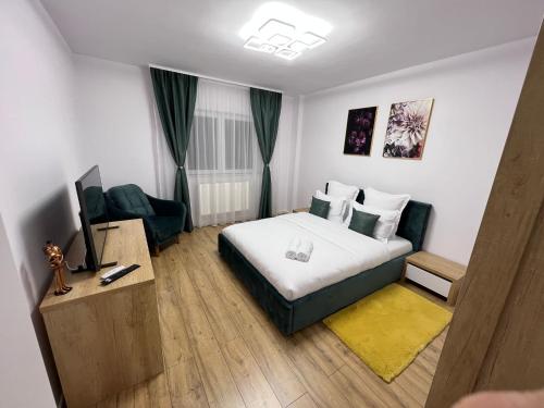 克卢日-纳波卡Aparthotel Junior4 Cluj的酒店客房,配有床和电视