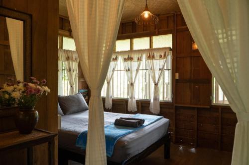 清道Art House at Chiangdao - Moon House的一间卧室配有床和带窗帘的窗户