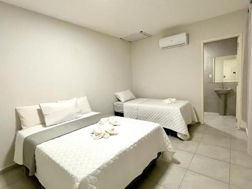 嘎林海斯港Casa em Porto de Galinhas by AFT的一间卧室配有两张带毛巾的床