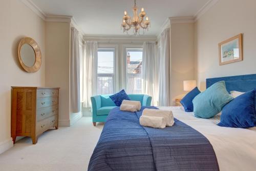 亨斯坦顿Fabulous Seaside Retreat的一间卧室配有蓝色的床和蓝色椅子