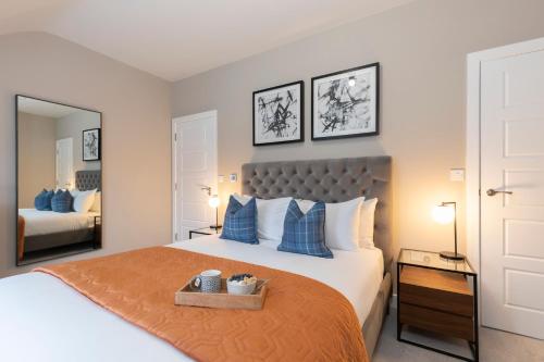 格洛斯特Elliot Oliver - Stylish Loft Style Two Bedroom Apartment With Parking的一间卧室配有一张带蓝色枕头的大床