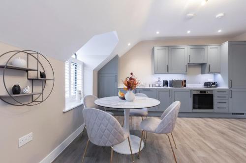 格洛斯特Elliot Oliver - Stylish Loft Style Two Bedroom Apartment With Parking的厨房以及带桌椅的用餐室。