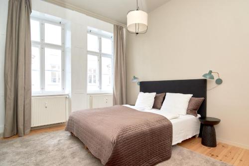 哥本哈根Scandinavian Style 3BR in Copenhagen City Centre的一间卧室配有一张带白色床单和窗户的床。