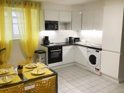 卢尔德Appartements Sun, parking, centre ville , proche Sanctuaires的厨房配有白色橱柜、洗衣机和烘干机