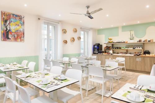 尼斯尼斯佛罗伦萨酒店的用餐室配有白色的桌子和白色的椅子