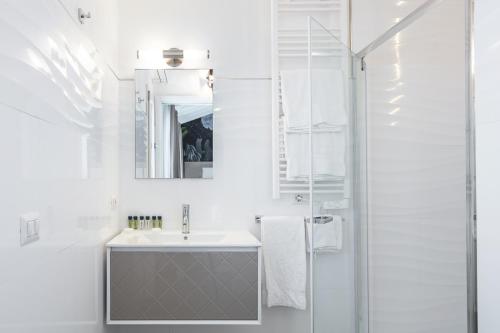 奥尔比亚Lungomare Rooms的白色的浴室设有水槽和淋浴。
