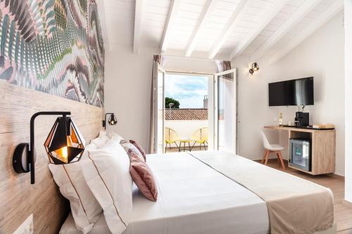 奥尔比亚Lungomare Rooms的一间带一张白色大床的卧室和一个阳台