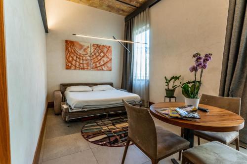 罗马加斯米特城市套房公寓式酒店的卧室配有一张床和一张桌子及椅子