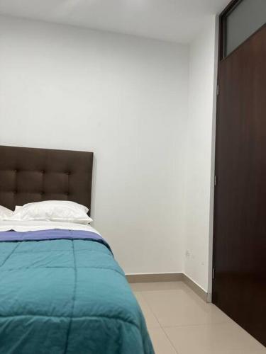 伊察Apartamento en Ica 3的一间卧室配有一张带蓝色毯子的床