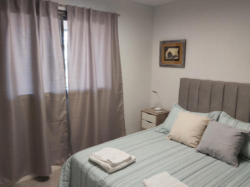门多萨Luminoso departamento en zona residencial的一间卧室配有一张床,上面有两条毛巾