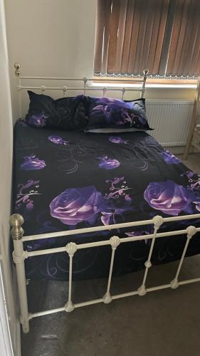莱斯特Spacious Double Room的一张带黑色和紫色棉被的床