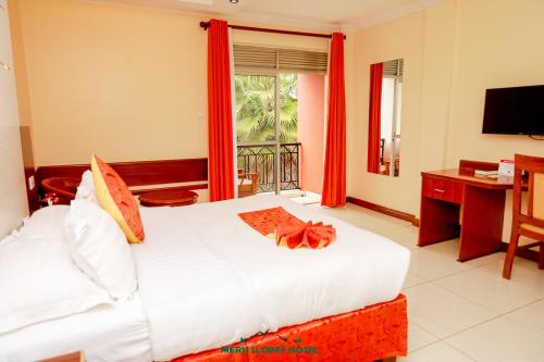 MeruMeru Slopes Hotel的一间卧室配有一张床、一张书桌和一个窗户。