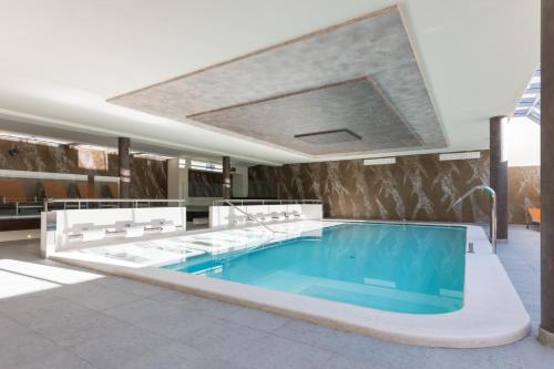 博萨迪法萨Hotel Crepei的一座大楼中央的游泳池