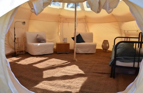 卡兰茨奥赫Stargazer Tent met sterrenuitzicht的帐篷配有两把椅子和一张床