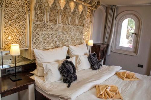 拉马坦萨德亚森特霍El Refugio Apartments & Villa的一间卧室配有一张带白色床单的床和一扇窗户。