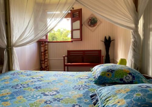 Le Morne RougeLE DOMAINE DE LA VALLEE的一间卧室配有一张带蓝色棉被的床和窗户。