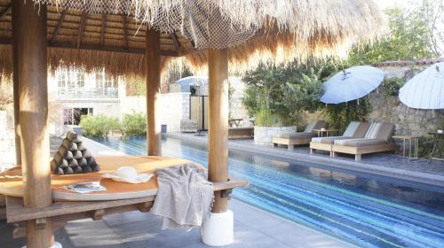 阿拉恰特奥拉夫亚酒店的一个带游泳池、桌子和遮阳伞的度假村