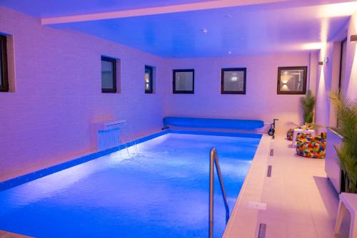 阿尔巴尤利亚Hotel Aura Unirii的蓝色灯光的房子里的一个游泳池