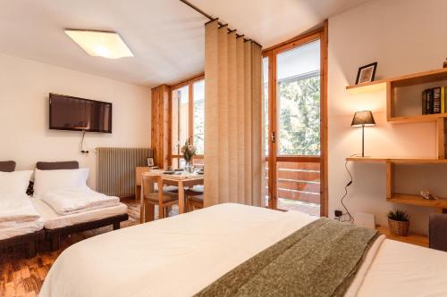 阿尔巴迪卡纳泽伊[* * *Premium Loft* * *] vista Marmolada的一间卧室配有一张床、一张书桌和一个窗户。