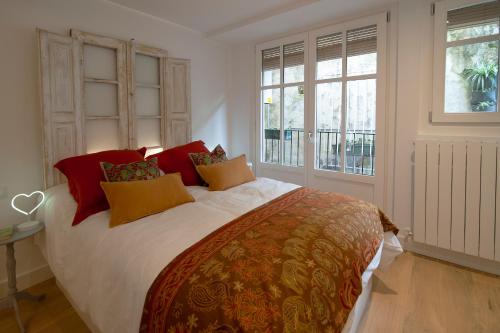 雷凯蒂奥Aittitta Makurra etxea的一间卧室配有一张大床,提供红色和黄色枕头